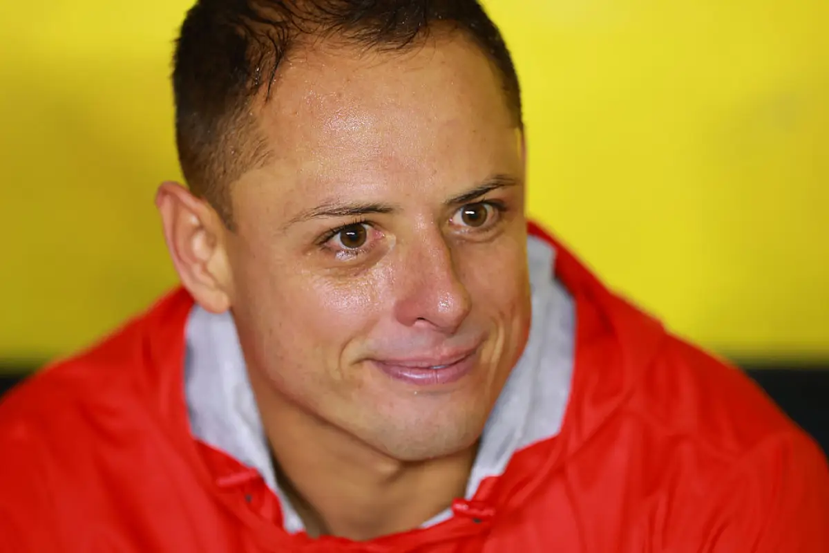Foto de Javier Chicharito Hernández durante un partido América-Chivas el 13 de septiembre de 2025, viste chamarra roja y tiene una expresión de tristeza.