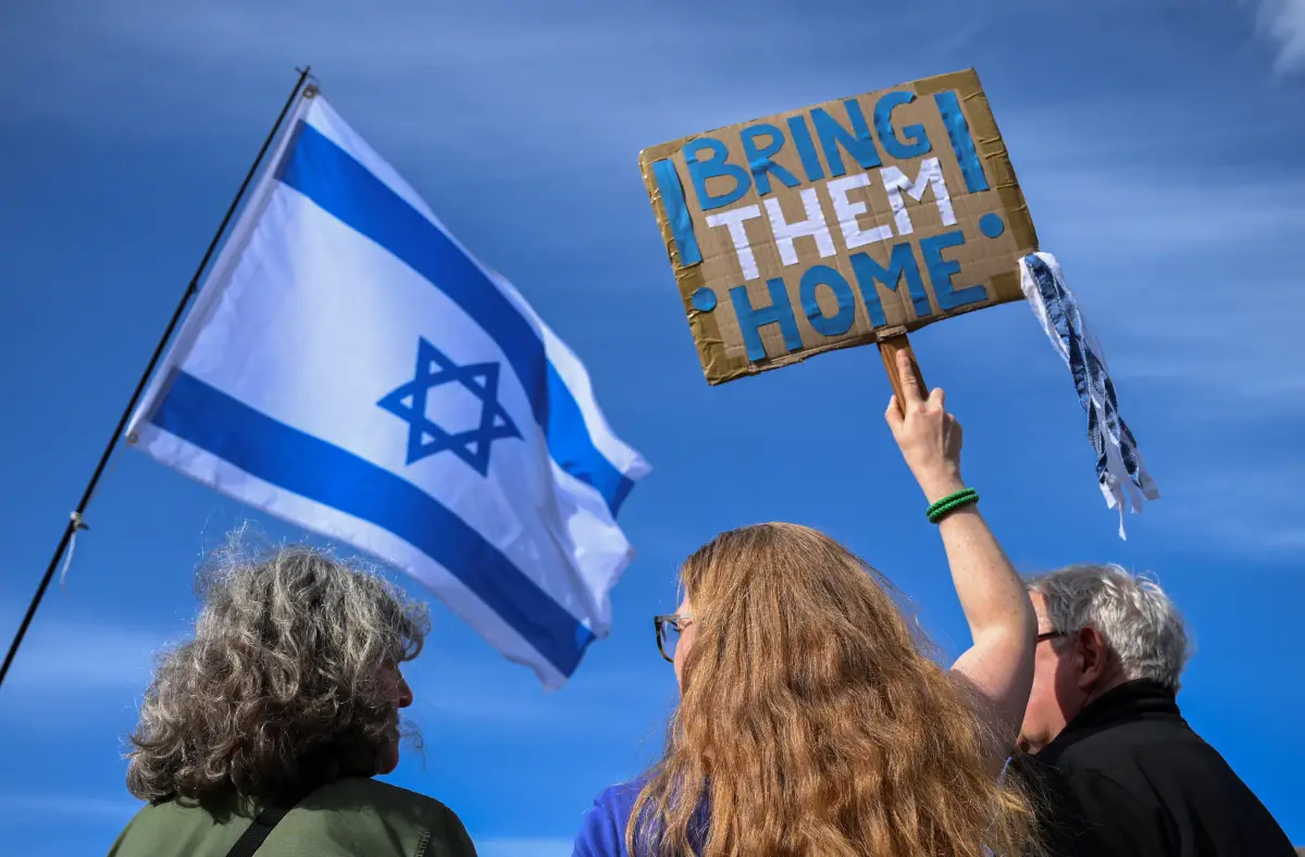 Personas que sostienen una bandera israelí y un cartel que pide traer a los rehenes del ataque del 7 de octubre a casa, se reúnen para un mitin en solidaridad con Israel, después de que Irán lanzara drones y misiles hacia Israel, en Berlín, Alemania, el 14 de abril de 2024.