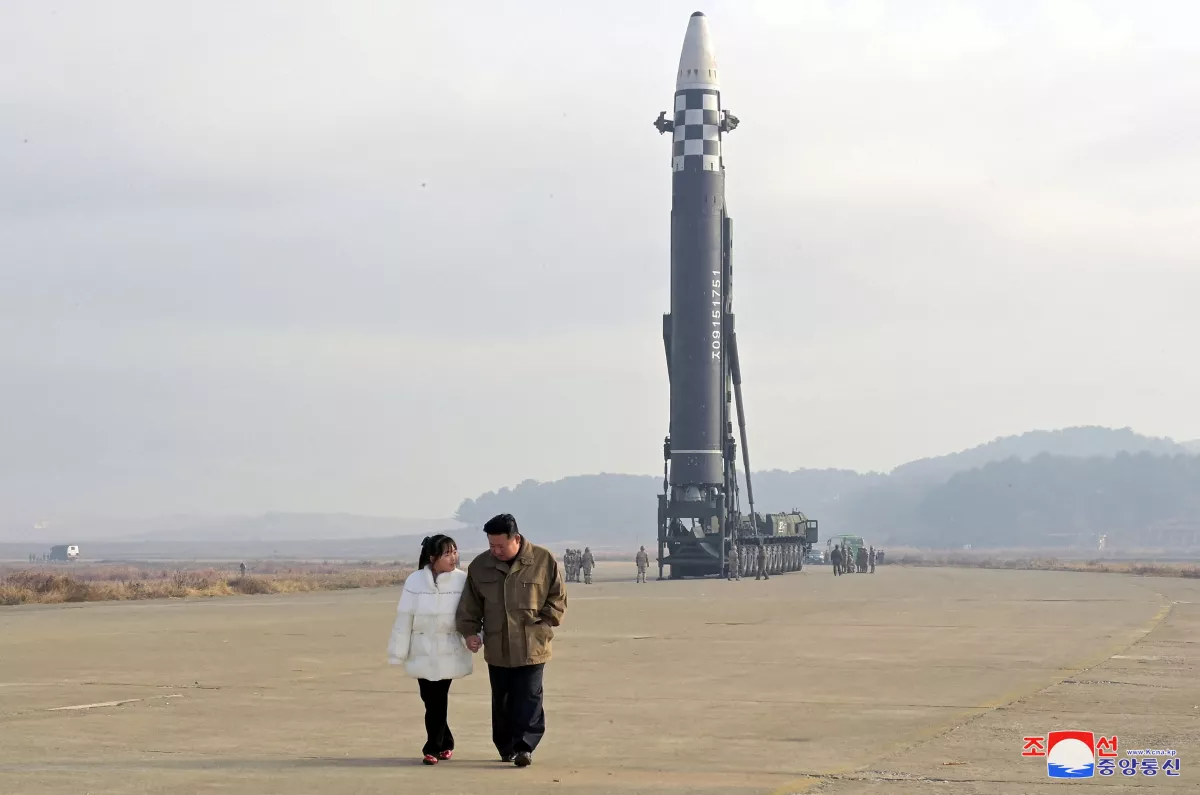 FILE PHOTO: North Korean leader Kim Jong Un, along with his daughter, walks away from an ICBM in this undated photo released by KCNA