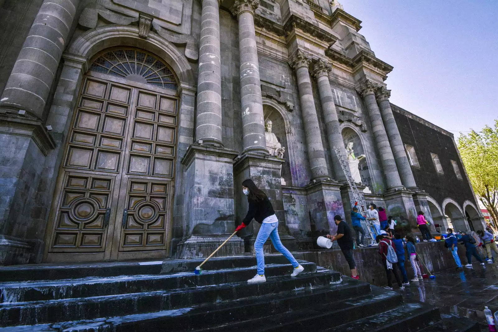Jóvenes católicos realizan labores de limpieza en la Catedral de Toluca en donde se realizaron durante la marcha del 8M.