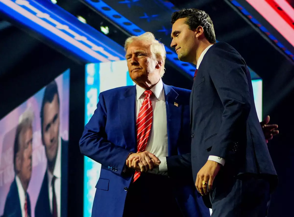 El presidente electo de los Estados Unidos, Donald Trump, estrecha la mano del fundador de Turning Point USA, Charlie Kirk, en el AmericaFest de Turning Point USA en Phoenix, Arizona, EE. UU., el 22 de diciembre de 2024.