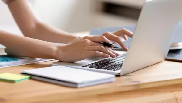 Closeup cropped image student girl hands typing using laptop
