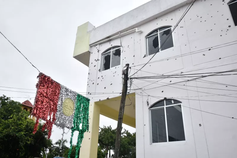 Una bandera desgarrada y los hoyos de las balas se observan en la fachada del Palacio Municipal de San Miguel Totoloapan, ayer un comando armado asesinó a 20 personas en su interior, entre ellas el presidente municipal Conrado Mendoza.