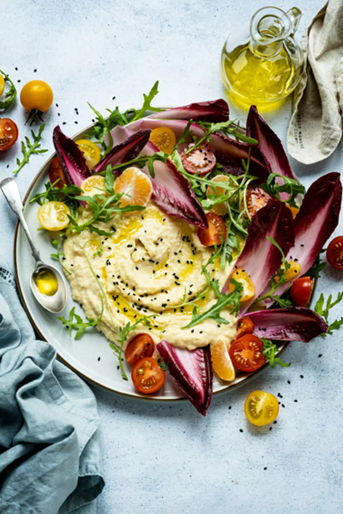 Foto de un plato de hummus con distintos tipos de tomates.