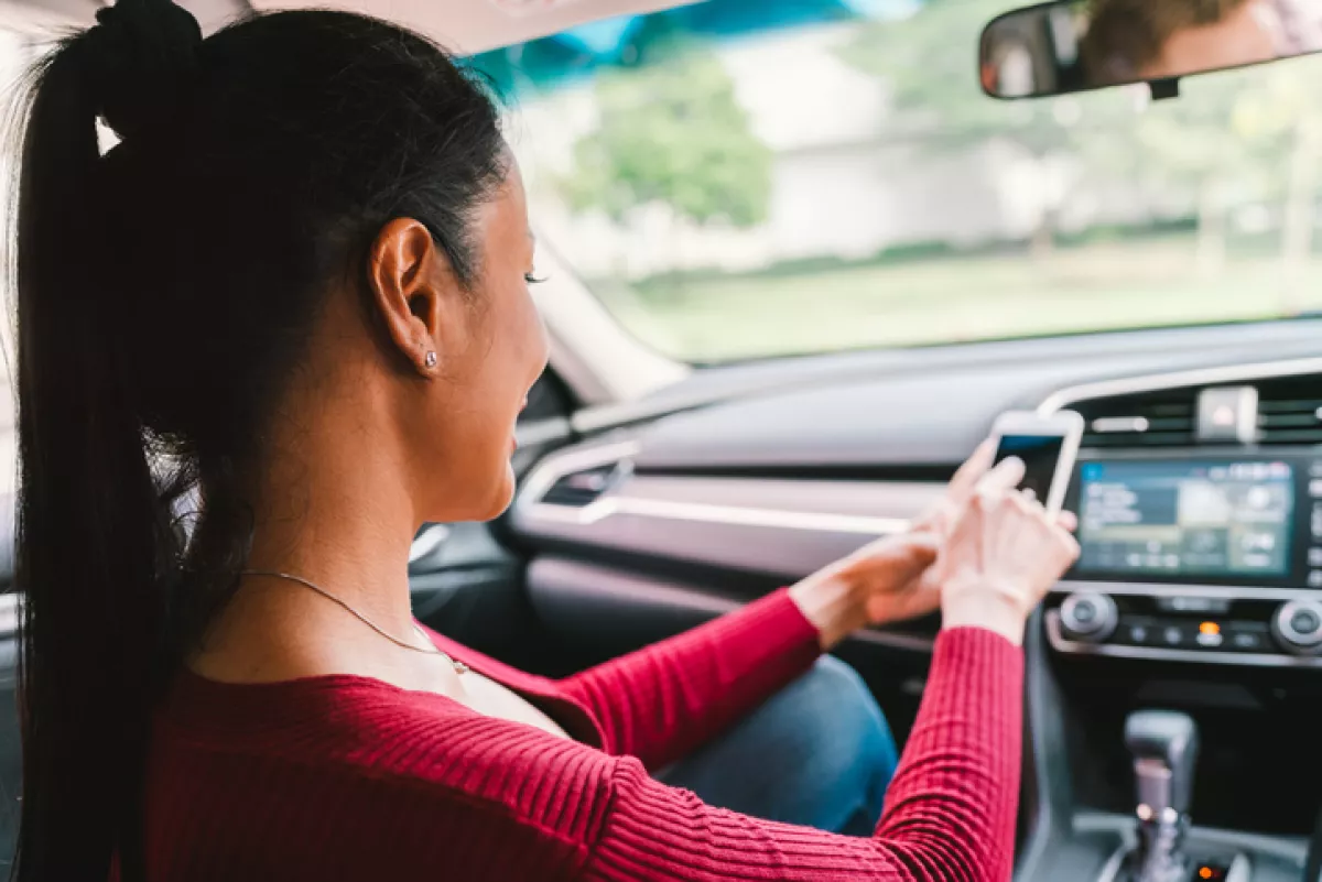 Woman using smartphone app on modern car. Mobile phone application, map navigation device technology, transportation, or crowdsourcing taxi concept