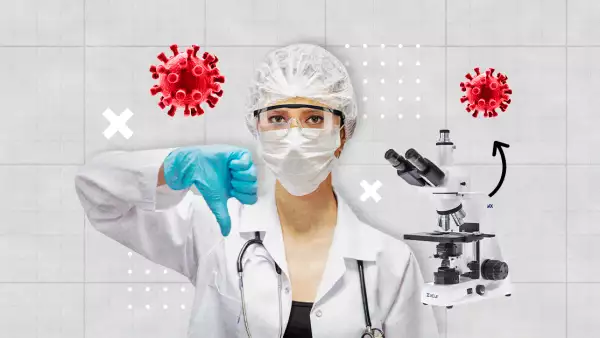 Una mujer con bata, cubrebocas, lentes de protección, gorra quirúrgica y guantes azules baja el pulgar.