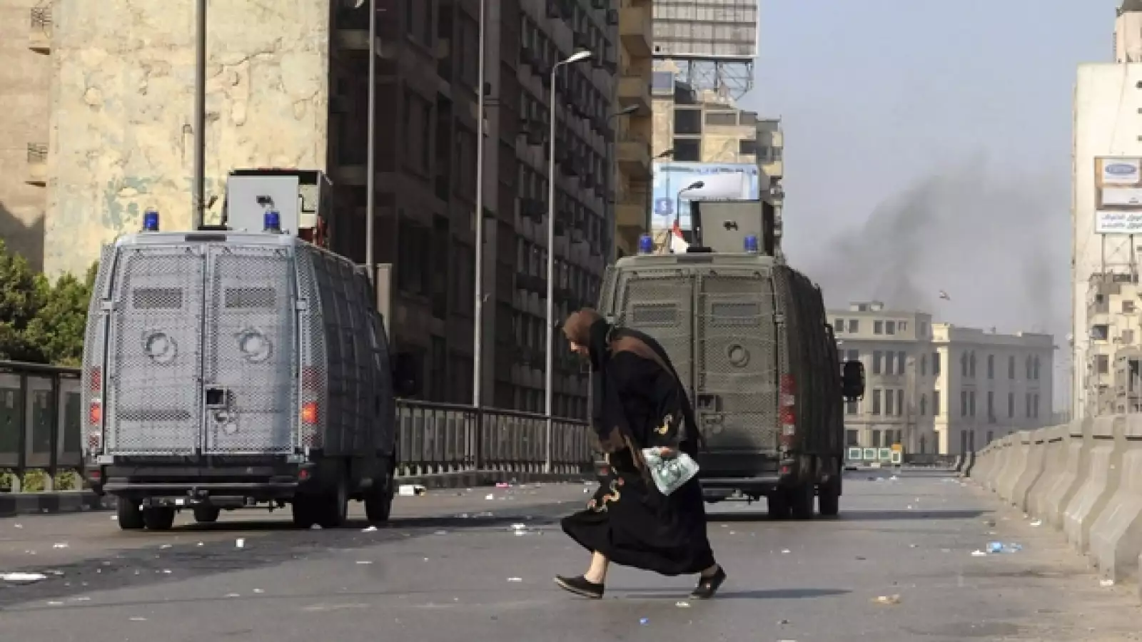 una mujer cruza una calle en durante los enfrentamientos