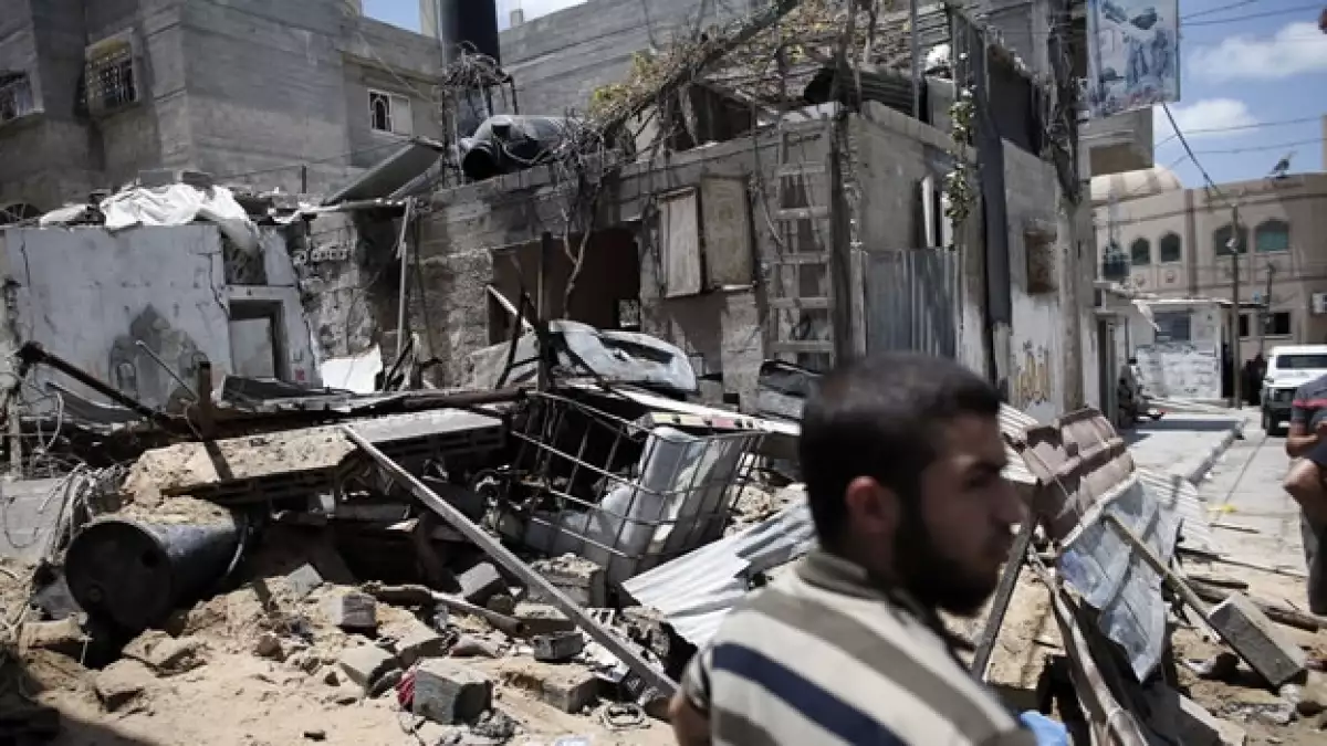 Un integrante de Hamas se mantiene alerta frente a un edificio destruido por un ataque aéreo de Israel este lunes, en Gaza