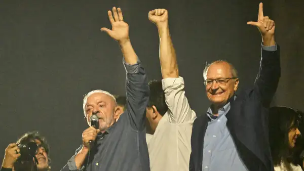 Lula da Silva levanta mano izquierda en la cual se observa la falta de su dedo meñique. Lo acompaña el vicepresidente.jpg