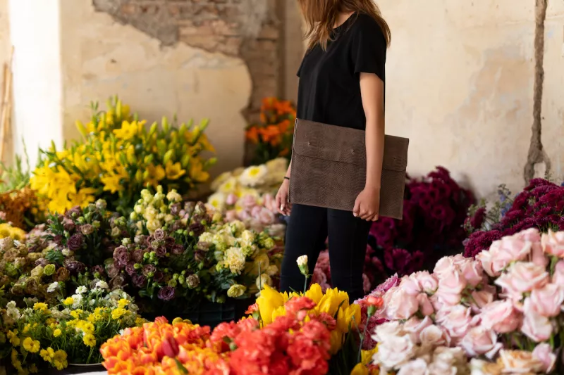 Mujer sosteniendo un porta laptop de piel.