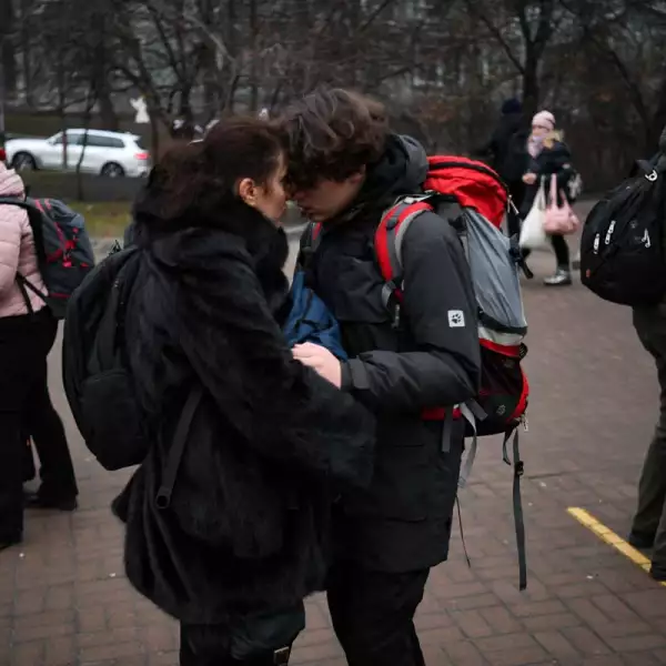 Una pareja con una maleta se abraza fuera de una estación de metro en Kiev. 