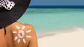 Woman with sun-shaped sun cream