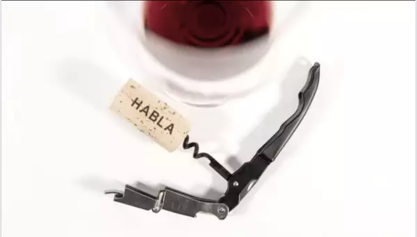 Copa de vino tinto y su corcho y destapacorcho.
