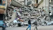 Esta foto tomada el 9 de abril de 2026, personas caminando en el lugar de los ataques aéreos israelíes del día anterior que atacaron el sur del barrio al-Shiyah de Beirut. El ejército israelí dijo que atacó a un comandante de Hezbolá en Beirut el 8 de abril, después de que los medios estatales libaneses informaran que Israel había atacado un barrio residencial en la capital.
