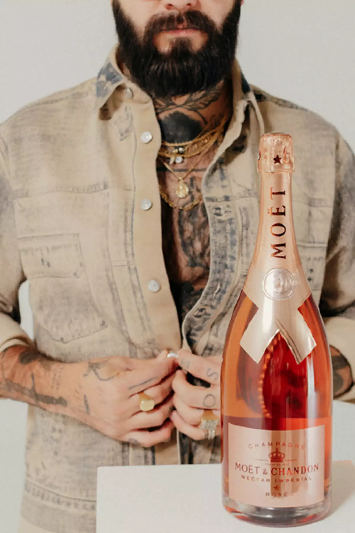 Foto del artista y tatuador Rodrigo Roji junto a una botella de Möet & Chandon, marca con la que tiene una colaboración artística.