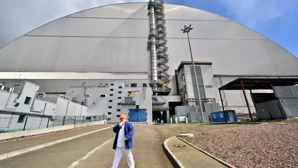Un empleado pasa por el Nuevo Confinamiento Seguro (NSC), cubriendo el cuarto reactor destruido en la Planta de Energía Nuclear de Chernobyl el 23 de abril de 2026.