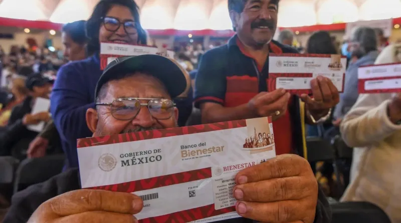 Adultos mayores sostienen un sobre de Programas del Bienestar.