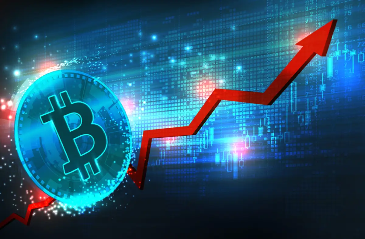 Imagen de un bitcoin junto a una gráfica con tendencia creciente.