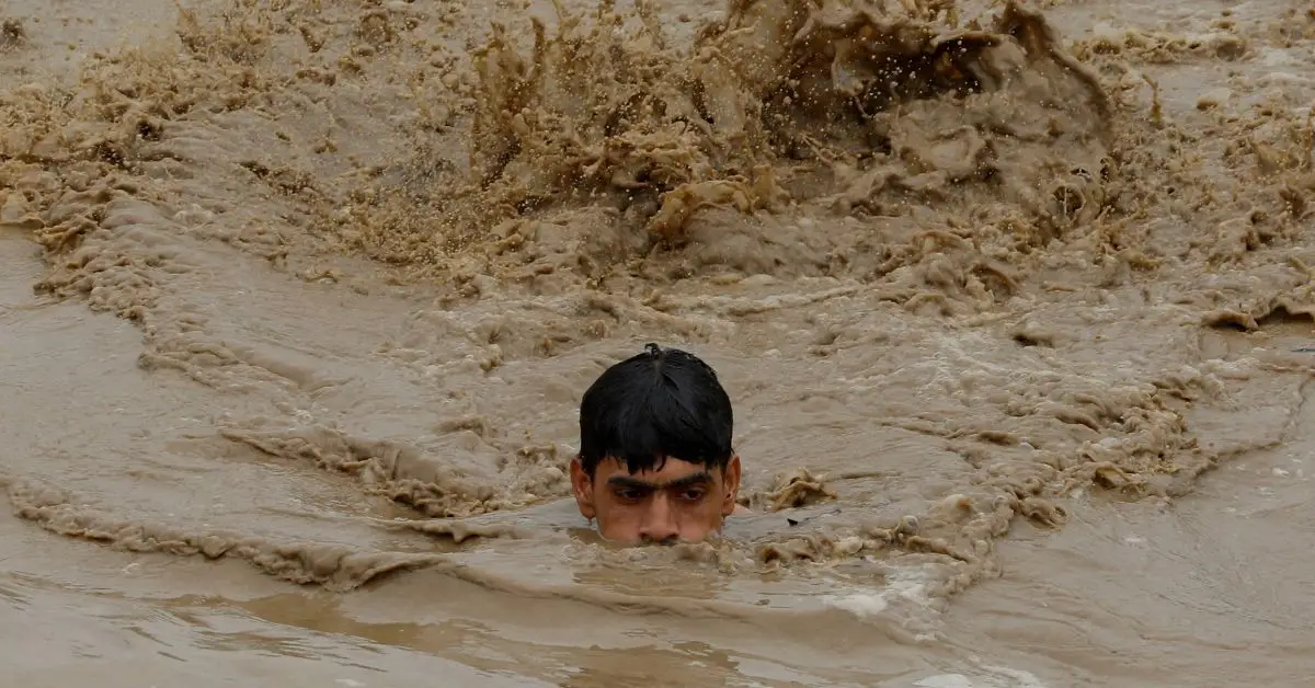 Un hombre nada en las aguas de la inundación mientras se dirige a un terreno más alto, después de lluvias e inundaciones durante la temporada de monzones en Charsadda, Pakistán, el 27 de agosto de 2022.