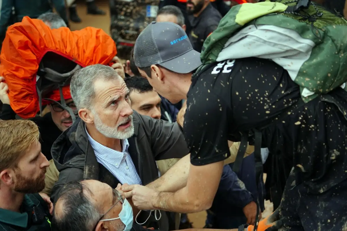 El rey Felipe VI de España (L) habla con una persona mientras los residentes enojados lo molestan durante su visita a Paiporta, en la región de Valencia, al este de España, el 3 de noviembre de 2024, después de las devastadoras inundaciones mortales.