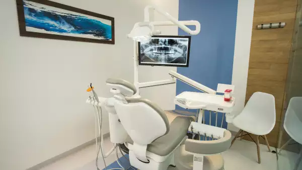 Consultorio dental con sillas y sillón para atender a pacientes.
