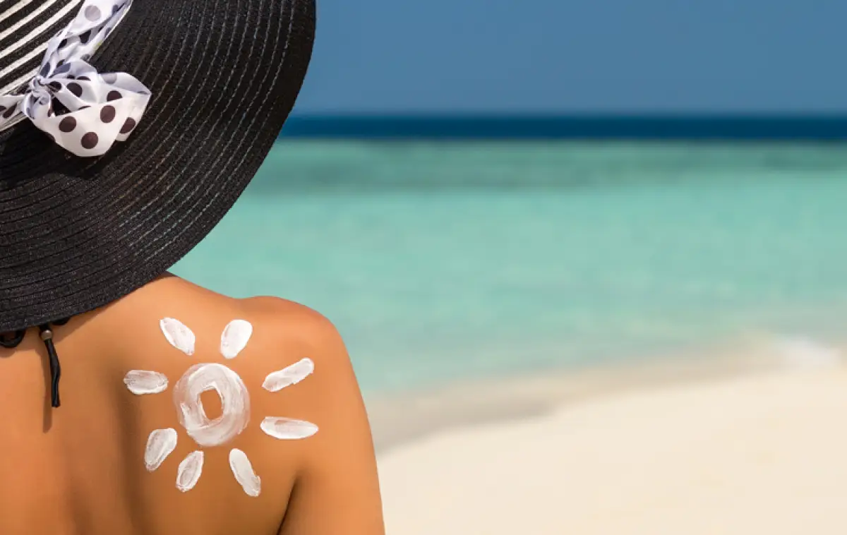 Woman with sun-shaped sun cream