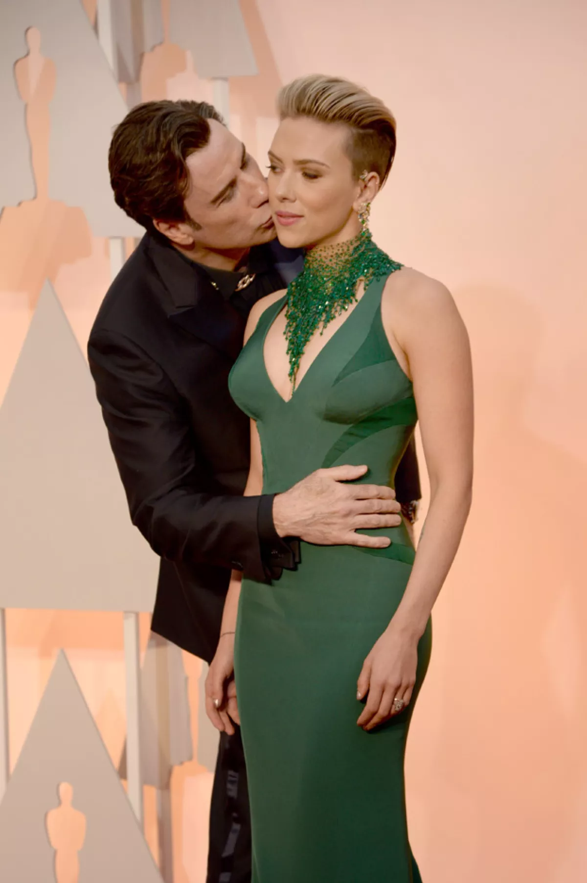 Scarlett sonrió nerviosamente al confirmar la presencia de Travolta detrás suyo.