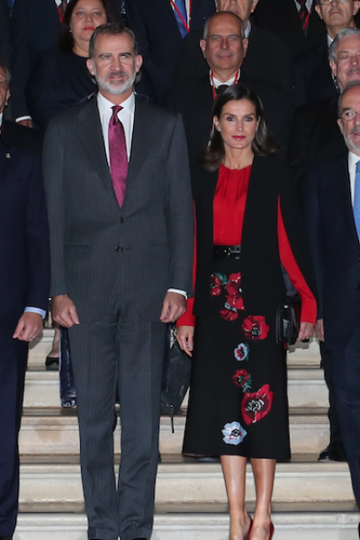 La Reina Letizia de Asturias hizo aparición en Sevilla con una blusa roja de manga larga, capa negra corta y una falda midi de estampado floral