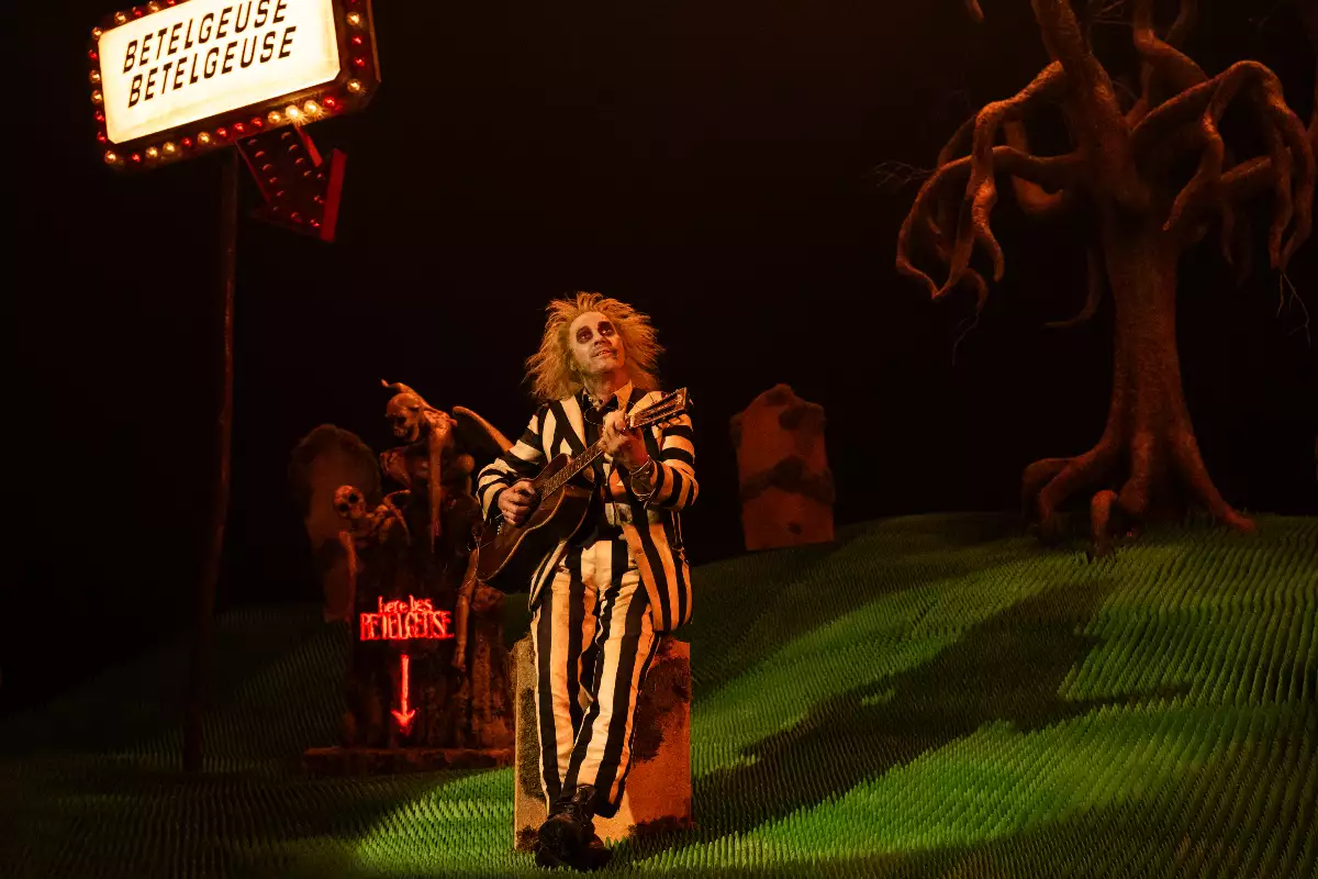 Foto de la película de Beetlejuice con el personaje de Michael Keaton tocando la guitarra dentro de una maqueta.