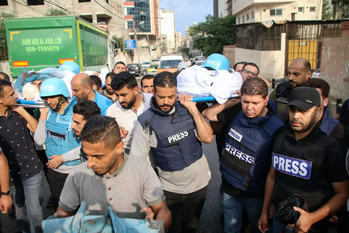 Amigos y familiares lloran los cuerpos de los periodistas palestinos Muhammad Sobh y Saeed Al-Taweel, que murieron durante su trabajo por ataques aéreos israelíes el 10 de octubre de 2023 en la ciudad de Gaza, Gaza.