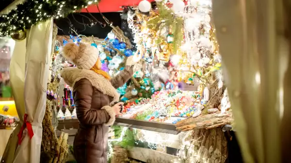 Woman standing  in front of Christmas street market stall