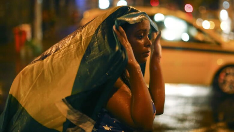 Una mujer mira al vacío en las calles de Rio al saber que su selección ha sido eliminada de la manera más contudente que pudo haber imaginado.