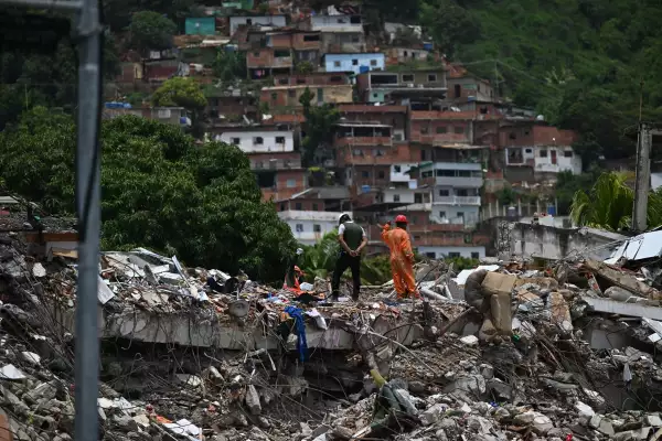 Un trabajador de rescate levanta la mano para silenciar a la gente para tratar de encontrar a los sobrevivientes en un edificio derrumbado después de los terremotos gemelos del 24 de junio, en Caraballeda, estado de La Guaira, Venezuela, el 30 de junio de 2026