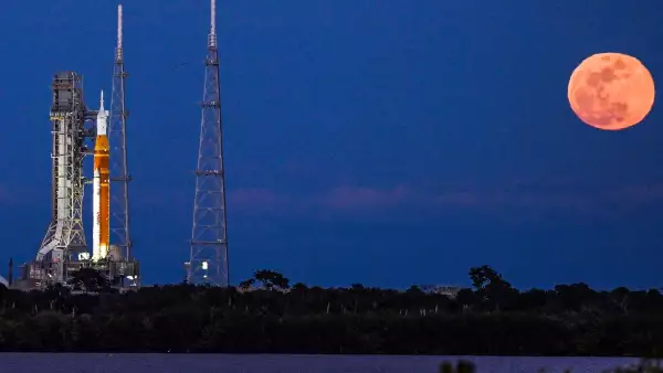 Una luna llena se levanta cuando el cohete del Sistema de Lanzamiento Espacial (SLS) y la nave espacial Orion, integrados para la misión Artemis II, se ven en la plataforma de lanzamiento 39B en el Centro Espacial Kennedy en Cabo Cañaveral, Florida, el 1 de febrero de 2026 antes de la primera misión tripulada a la Luna en más de 50 años.