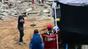 La gente espera noticias sobre los cuerpos de sus seres queridos frente a un edificio derrumbado en Caraballeda, estado de La Guaira, Venezuela, el 12 de julio de 2026, después de los terremotos gemelos que azotaron la región.