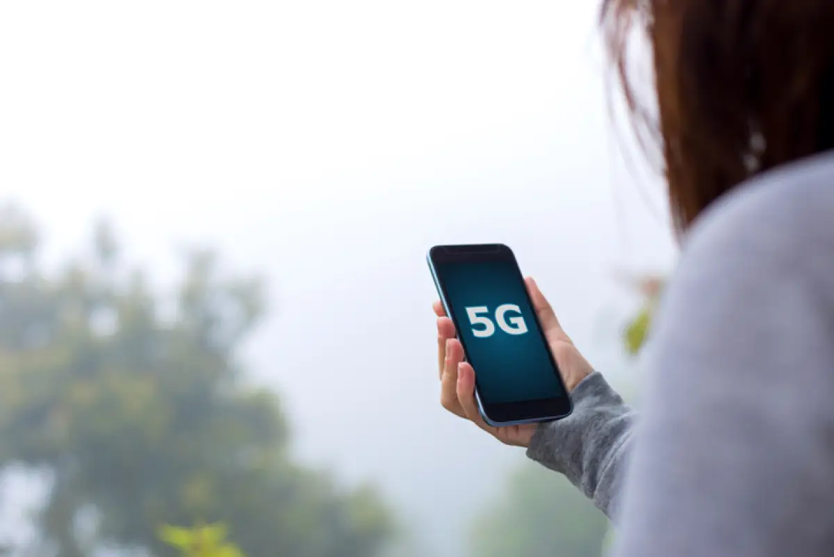 Young woman using 5G on smartphone