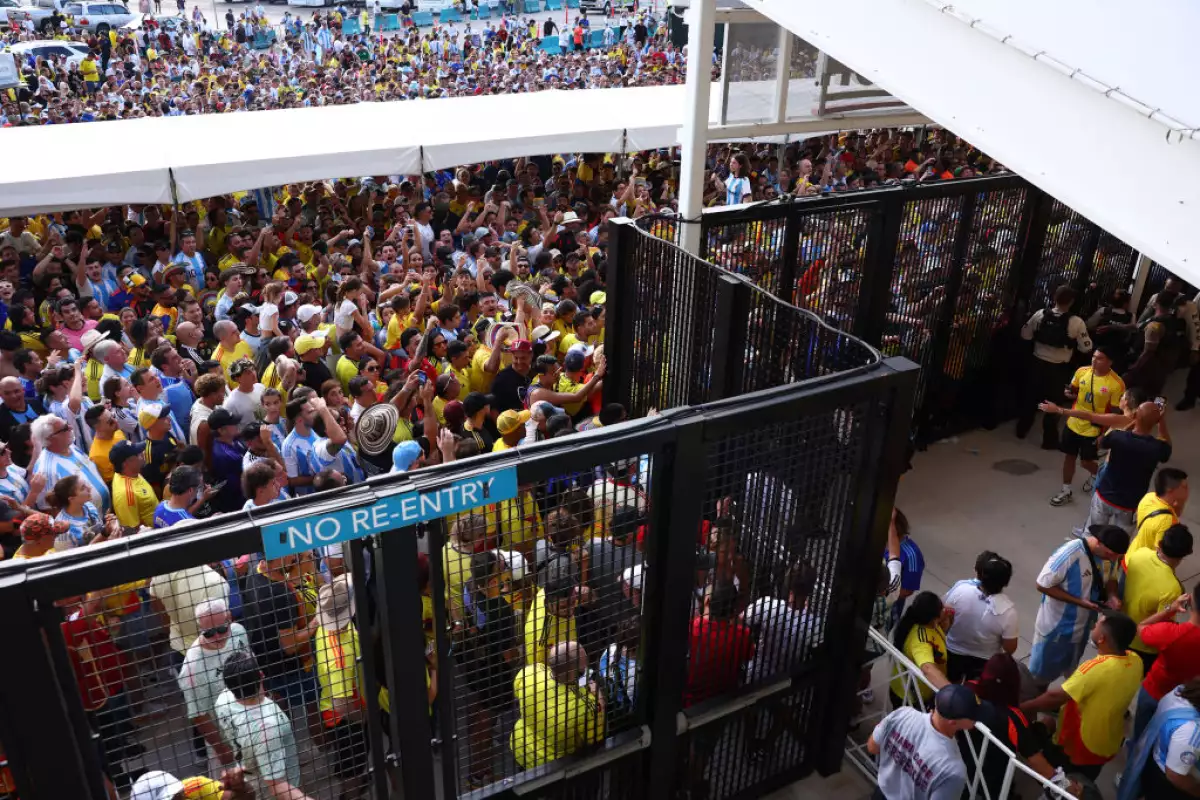 Foto de cientos de personas esperando frente a las rejas cerradas del estadio Hard Rock