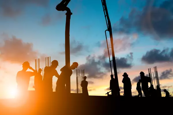 Silhouette construction industry team safely to work load concrete building according to set goal over blurred background sunset pastel for industry background.