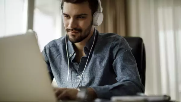 Young man using laptop and listening to music