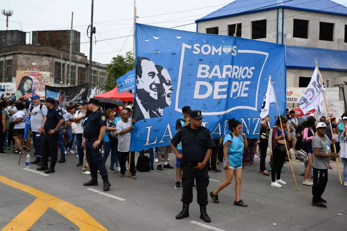Oficiales de policía están de guardia en una calle mientras miembros de organizaciones sociales protestan contra el decreto de emergencia del presidente argentino Javier Milei en La Matanza, provincia de Buenos Aires, Argentina, el 28 de diciembre de 2023.