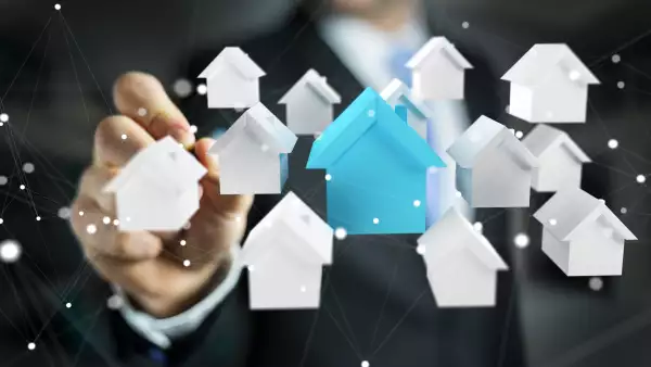 Businessman on blurred background using 3D rendered small white and blue houses