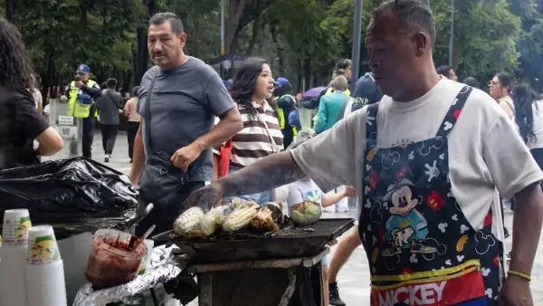 Un hombre vende elotes en la Alameda Central, frente al Palacio de Bellas Artes. 