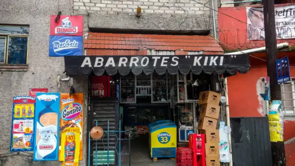 Fachada de tienda de abarrotes de nombre Kiki con letreros de Bimbo, Gansito, cajas de cerveza y refrescos.jpg