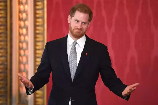 El principe Harry con un traje negro, camisa blanca y una corbata gris