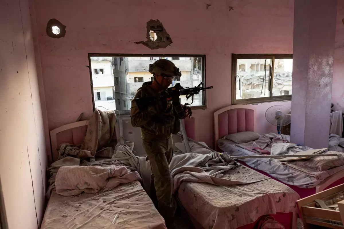 Teniente El coronel Ido camina a través de un dormitorio dañado, que se encuentra, según él, encima de un taller que se utilizó para la producción de armas dentro de un edificio residencial en medio de la invasión terrestre en curso contra el grupo islamista palestino Hamas en el norte de la Franja de Gaza, el 8 de noviembre de 2023.