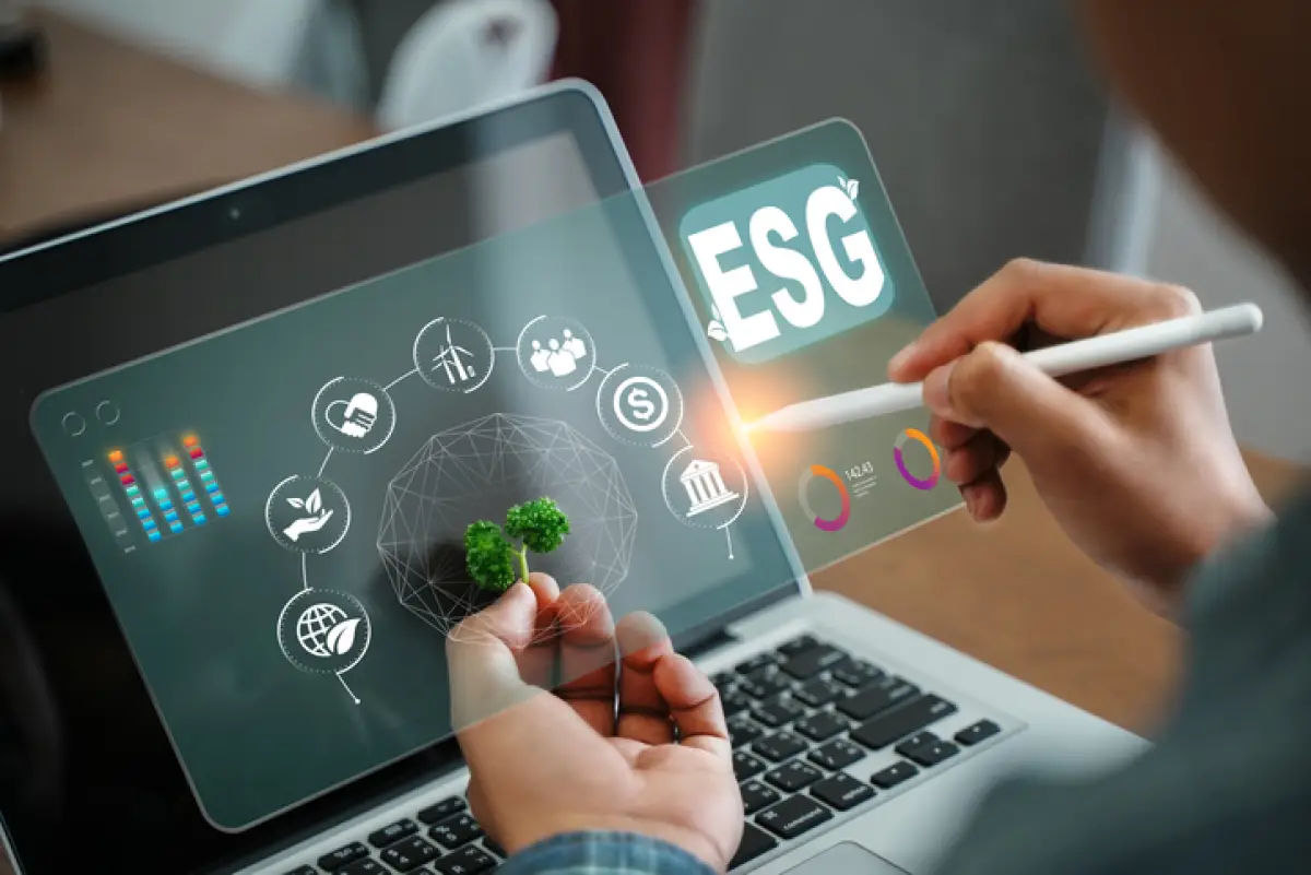 computadora con palabra ASG en el centro y gráficas financieras