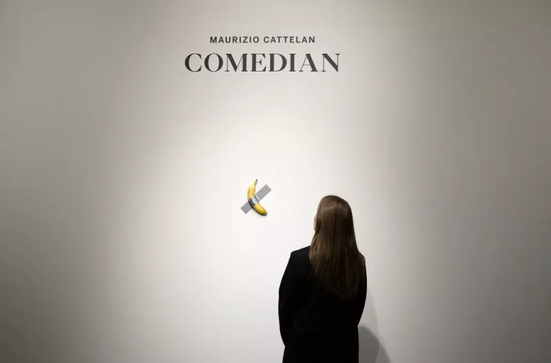 Foto de la obra del plátano pegado a la pared con cinta adhesiva titulada "The Comedian".