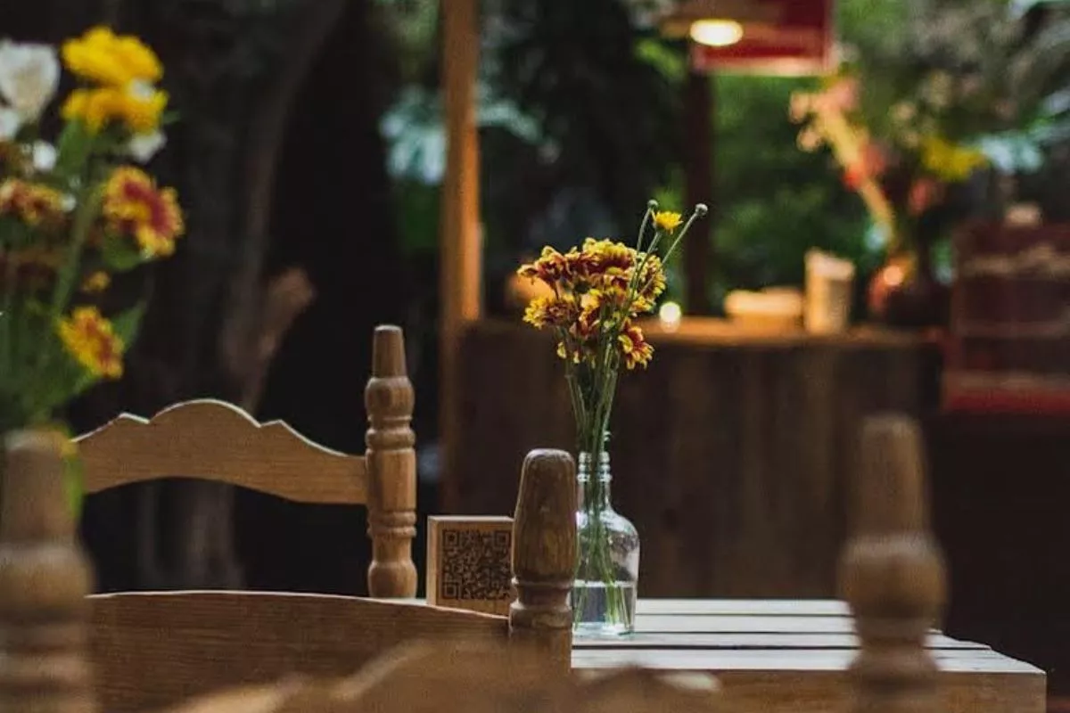 Juego de mesa y sillas de madera con florero y ambiente acogedor