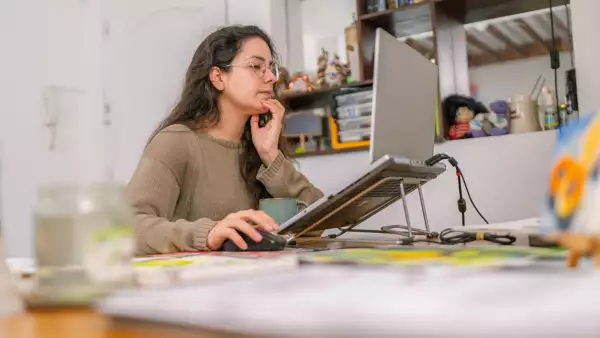 Graphic designer working from home on laptop in cozy studio