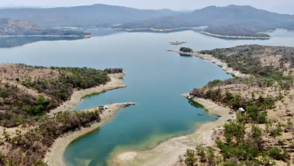 Un cuerpo de agua de diferentes tonalidades de azul en medio de zonas semiáridas y montañas con cielo azul.jpg
